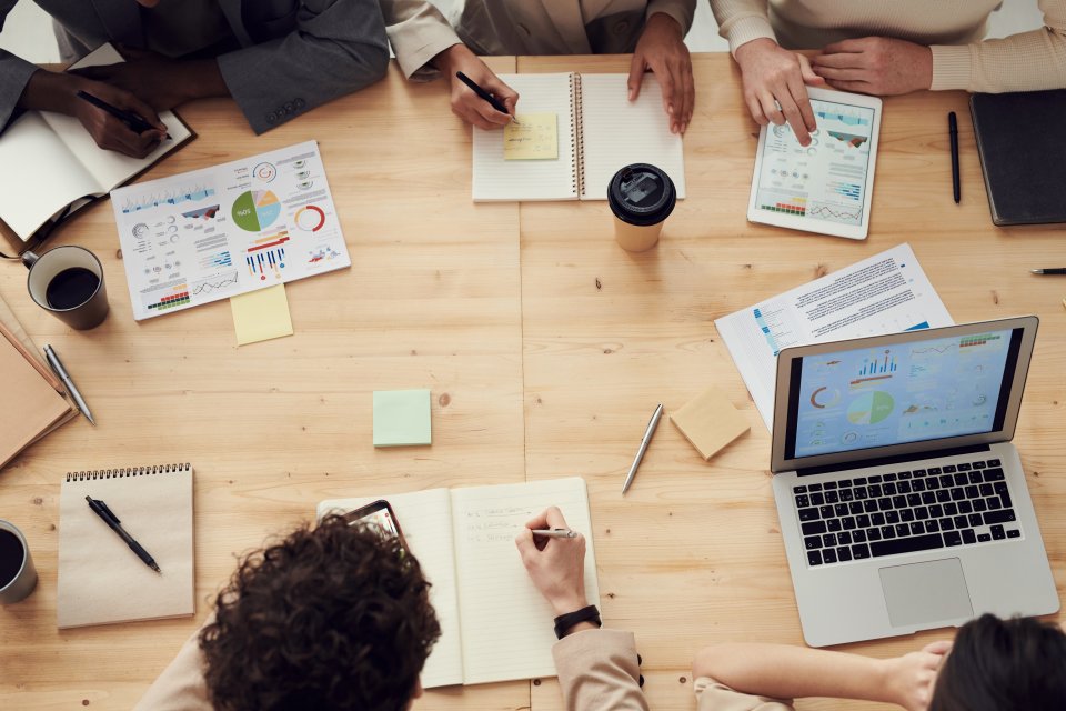 Top down view of a table surrounded by people with paperwork collaborating